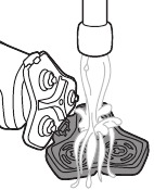 Izpiranje držala za brivno glavo pod toplo vodo