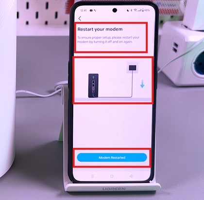 Screenshot van de app die vraagt om de modem opnieuw op te starten en de locatie te selecteren