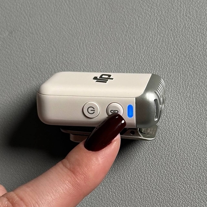 DJI Mic 2 предавател с мигаща синя светлина, показваща режим на Bluetooth сдвояване.