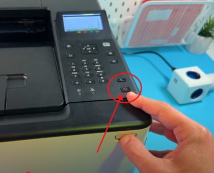 Mkono ukibonyeza kitufe cha nguvu kwenye printa ya Canon Sensus