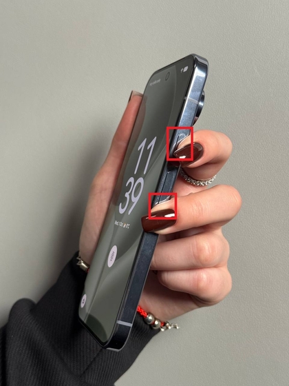 Nuotrauka, kurioje matyti ranka, laikanti nuspaudusi įjungimo mygtuką ir garsumo mažinimo mygtuką Pixel 10 Pro &scaron;one.