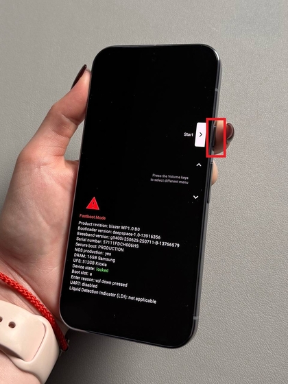 Nuotrauka, kurioje matyti ranka, spaudžianti įjungimo mygtuką Pixel 10 Pro, kad patvirtintų pasirinkimą Pradėti.