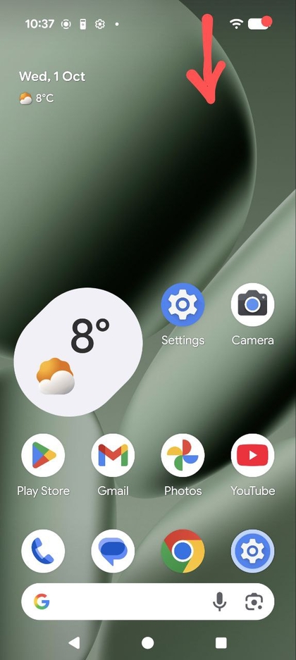 Screenshot van het startscherm van de Pixel 10 Pro met een pijl die het omlaagveeggebaar aangeeft om het paneel Snelle instellingen te openen.