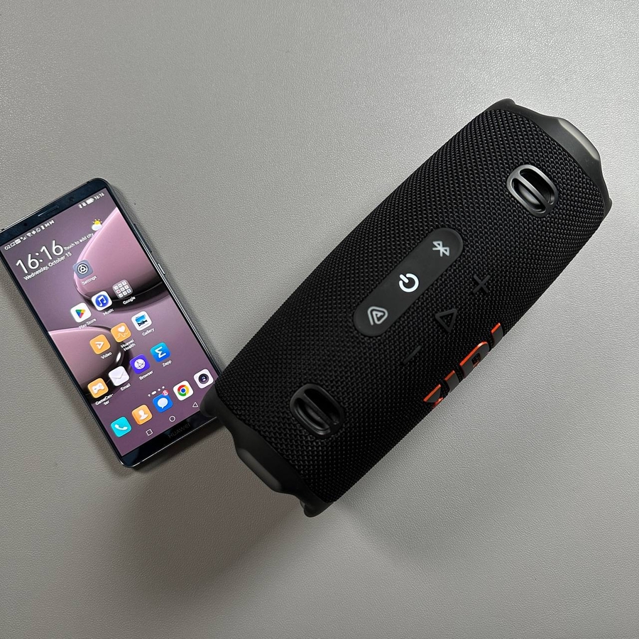 Zvočnik JBL Charge 6 poleg telefona Android